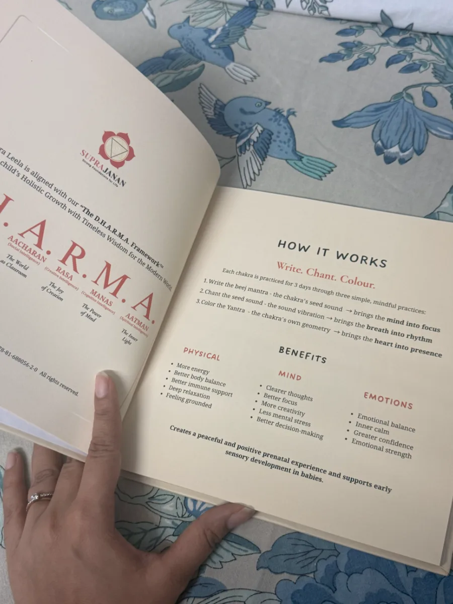 Chakra Leela open at the How it works page, held over a blue floral bedspread