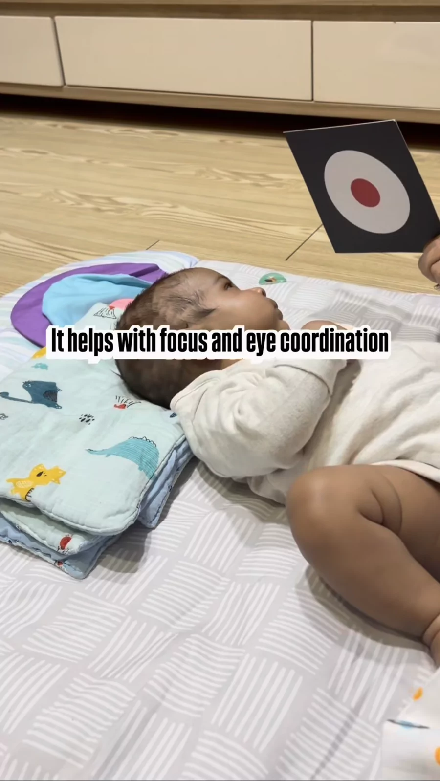 Baby tracking a high-contrast focus card, building eye coordination